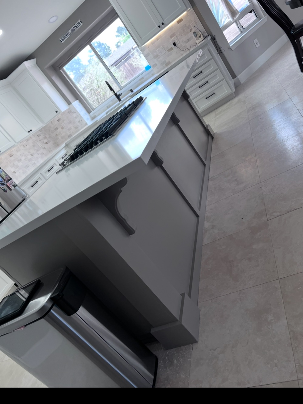 Completed white kitchen remodel with peninsula and cooktop